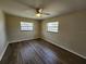 This bedroom features dark wood floors, a fan, and lots of natural light at 21035 Exmore Ave, Port Charlotte, FL 33952