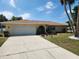 Charming single-story home with well-maintained lawn, landscaped beds, and a two-car garage at 21035 Exmore Ave, Port Charlotte, FL 33952