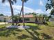 Home with attractive landscaping featuring palm trees and rock mulch, creating a tropical ambiance at 21035 Exmore Ave, Port Charlotte, FL 33952