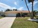Well-maintained home with a spacious driveway and landscaping offering curb appeal at 21035 Exmore Ave, Port Charlotte, FL 33952