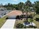 Charming single-story home with a well-manicured lawn, beautiful palm trees and a two-car garage at 21035 Exmore Ave, Port Charlotte, FL 33952
