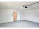 The garage interior has a grey painted floor, white walls, and a doorway with a white door leading to the house interior at 21035 Exmore Ave, Port Charlotte, FL 33952