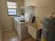 Well-lit laundry room with a washing machine, dryer, utility sink, and a water heater, providing convenience for household chores at 21035 Exmore Ave, Port Charlotte, FL 33952