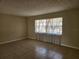 Bright living room area showcasing tile flooring, neutral walls, and a large window at 21035 Exmore Ave, Port Charlotte, FL 33952