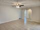 Living room with neutral paint, ceiling fan, and tile floors; multiple doorways visible at 21035 Exmore Ave, Port Charlotte, FL 33952