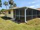Side and back of home featuring a large screen patio for outdoor living at 21035 Exmore Ave, Port Charlotte, FL 33952