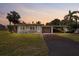 Charming single-story home with well-maintained lawn, driveway, and carport at sunset at 23491 Harper Ave, Punta Gorda, FL 33980