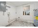 Utility room with water heater and hookups, showcasing functional space at 23491 Harper Ave, Punta Gorda, FL 33980