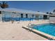 Community pool with a clear blue swimming pool and building with ocean-themed mural and a light blue roof at 25225 Rampart Blvd # 1801, Punta Gorda, FL 33983
