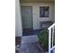 Inviting condo entrance with a green front door, bench, and a small garden at 25225 Rampart Blvd # 1801, Punta Gorda, FL 33983
