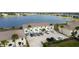 Aerial view showcasing building exteriors, parking, and lake in the background at 26290 Rampart Blvd # D, Punta Gorda, FL 33983