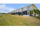 Backyard view with patios, and white balconies overlooking a grassy area at 26290 Rampart Blvd # D, Punta Gorda, FL 33983