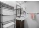 Well-lit bathroom features a dark vanity, decorative mirror, and storage shelving at 26290 Rampart Blvd # D, Punta Gorda, FL 33983