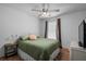 Cozy bedroom with green bedding, accent pillows, and view to white wicker table at 26290 Rampart Blvd # D, Punta Gorda, FL 33983