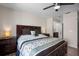 Spacious bedroom featuring wooden floors, ceiling fan, and view to modern bathroom at 26290 Rampart Blvd # D, Punta Gorda, FL 33983
