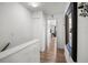 Hallway view with wood floor, mirror, closet, and entry to another room at 26290 Rampart Blvd # D, Punta Gorda, FL 33983