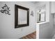 Hallway featuring decorative mirror and glimpse of bedroom through doorway at 26290 Rampart Blvd # D, Punta Gorda, FL 33983