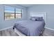 This bedroom features a queen bed, hardwood floors, and a large window at 26485 Rampart Blvd # C1, Punta Gorda, FL 33983