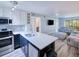 Living room with modern kitchen view featuring stainless steel appliances, white countertops at 26485 Rampart Blvd # C1, Punta Gorda, FL 33983
