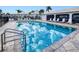 Community pool with sparkling blue water reflecting the sky, surrounded by lounge chairs at 26485 Rampart Blvd # C1, Punta Gorda, FL 33983