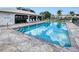 Community swimming pool on a sunny day with lounge chairs around the edge at 26485 Rampart Blvd # C1, Punta Gorda, FL 33983