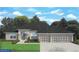 Charming single-story home featuring a three-car garage, landscaped front yard, and classic architectural design at 277 Long Meadow Ln, Rotonda West, FL 33947