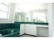 Upscale bathroom with a soaking tub, spacious vanity, large mirror, and bright lighting at 29211 Picador St, Punta Gorda, FL 33982