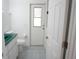 Bathroom features a toilet, cabinet with sink, gray tile floors, and access door at 29211 Picador St, Punta Gorda, FL 33982