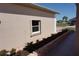 Home exterior featuring a garden bed with plants next to a neutral stucco wall and window at 29211 Picador St, Punta Gorda, FL 33982