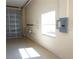 Spacious garage featuring roll-up door, built-in shelving, and a bright window, offering ample storage and natural light at 29211 Picador St, Punta Gorda, FL 33982