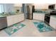 Bright kitchen featuring white cabinets, stainless steel appliances, and cute ocean themed mats at 29211 Picador St, Punta Gorda, FL 33982