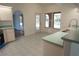 Bright kitchen with white cabinets, tile floor, and arched doorway to adjacent rooms at 29211 Picador St, Punta Gorda, FL 33982