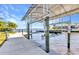 View of a boat lift on canal with tropical landscaping in the background at 3016 Curry Ter, Port Charlotte, FL 33981