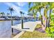 Dockside view of a waterfront home, equipped with a boat lift and providing access to picturesque canal waters at 3016 Curry Ter, Port Charlotte, FL 33981