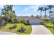 Beautiful home featuring a three-car garage, manicured lawn, and tropical landscaping at 3016 Curry Ter, Port Charlotte, FL 33981
