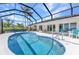 Backyard pool area with a screened enclosure and a view of the tropical palm trees and blue sky at 3016 Curry Ter, Port Charlotte, FL 33981
