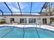 Swimming pool with a screen enclosure, poolside furniture, and sliding glass doors to the house at 3016 Curry Ter, Port Charlotte, FL 33981