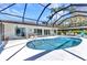 Screened-in pool area features a kidney-shaped pool, white concrete patio, and outdoor seating at 3016 Curry Ter, Port Charlotte, FL 33981