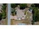 Overhead view of a well-maintained home with mature trees, manicured lawns, and a brick driveway and walkways at 3051 Chicory Ter, Punta Gorda, FL 33983