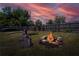 Inviting backyard featuring a stone fire pit, picnic table, canoe, and raised garden beds, perfect for outdoor gatherings at 3051 Chicory Ter, Punta Gorda, FL 33983