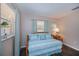 Bright bedroom with blue and white bedding, complemented by natural light from the window at 3051 Chicory Ter, Punta Gorda, FL 33983