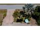 Aerial shot of meticulously landscaped yard with a serene pond and a quaint seating area, shaded by mature trees at 3051 Chicory Ter, Punta Gorda, FL 33983