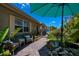 Charming walkway and front sitting area with comfortable wicker chairs, showcasing the lush tropical landscaping and inviting ambiance at 3051 Chicory Ter, Punta Gorda, FL 33983