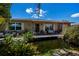 Inviting front of house with pond, dock, and comfortable seating area, enhanced by lush greenery and tasteful decor at 3051 Chicory Ter, Punta Gorda, FL 33983