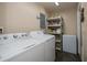 Functional laundry area with shelving and modern washer and dryer at 3051 Chicory Ter, Punta Gorda, FL 33983