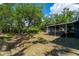 The backyard shows mature trees, an open yard, and a screened in lanai at 3175 Lakatos St, North Port, FL 34286