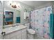 Cozy bathroom featuring a vanity with white cabinets, toilet, and a shower with patterned curtain at 3175 Lakatos St, North Port, FL 34286