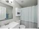 Bright bathroom features a white vanity, medicine cabinet and polka dot shower curtain at 3175 Lakatos St, North Port, FL 34286