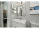 Bathroom with white vanity, dual mirrors, and a partial view of a shower at 3175 Lakatos St, North Port, FL 34286