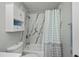 Bright bathroom featuring a shower/tub combo with blue and grey accents and built-in storage at 3175 Lakatos St, North Port, FL 34286